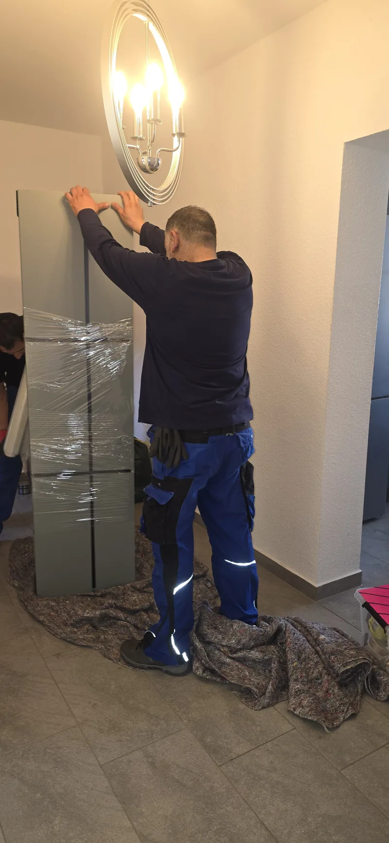 Mitarbeiter sichern ein Möbelstück für den Abtransport